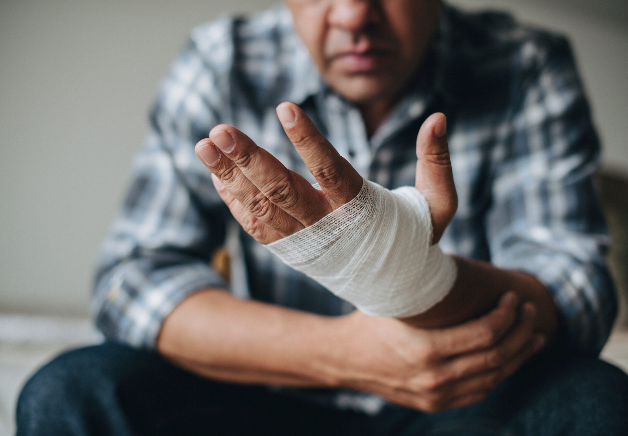 man holding an injured hand wrapped in gauze